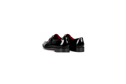 A pair of black patent leather oxford shoes with red lining, shown from a rear three-quarter angle on a solid white background.